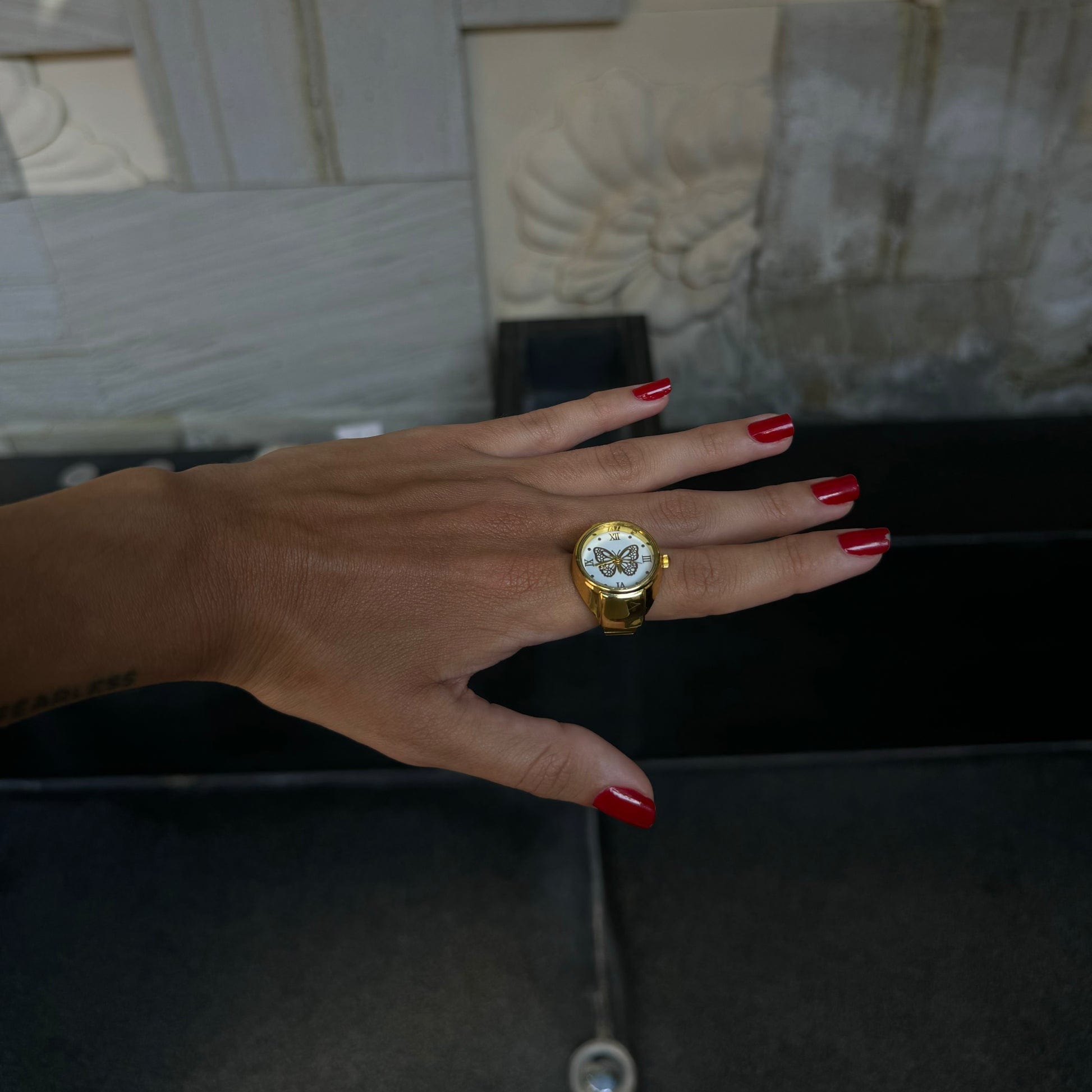 Aperçu de la bague montre dorée papillon sur index féminin