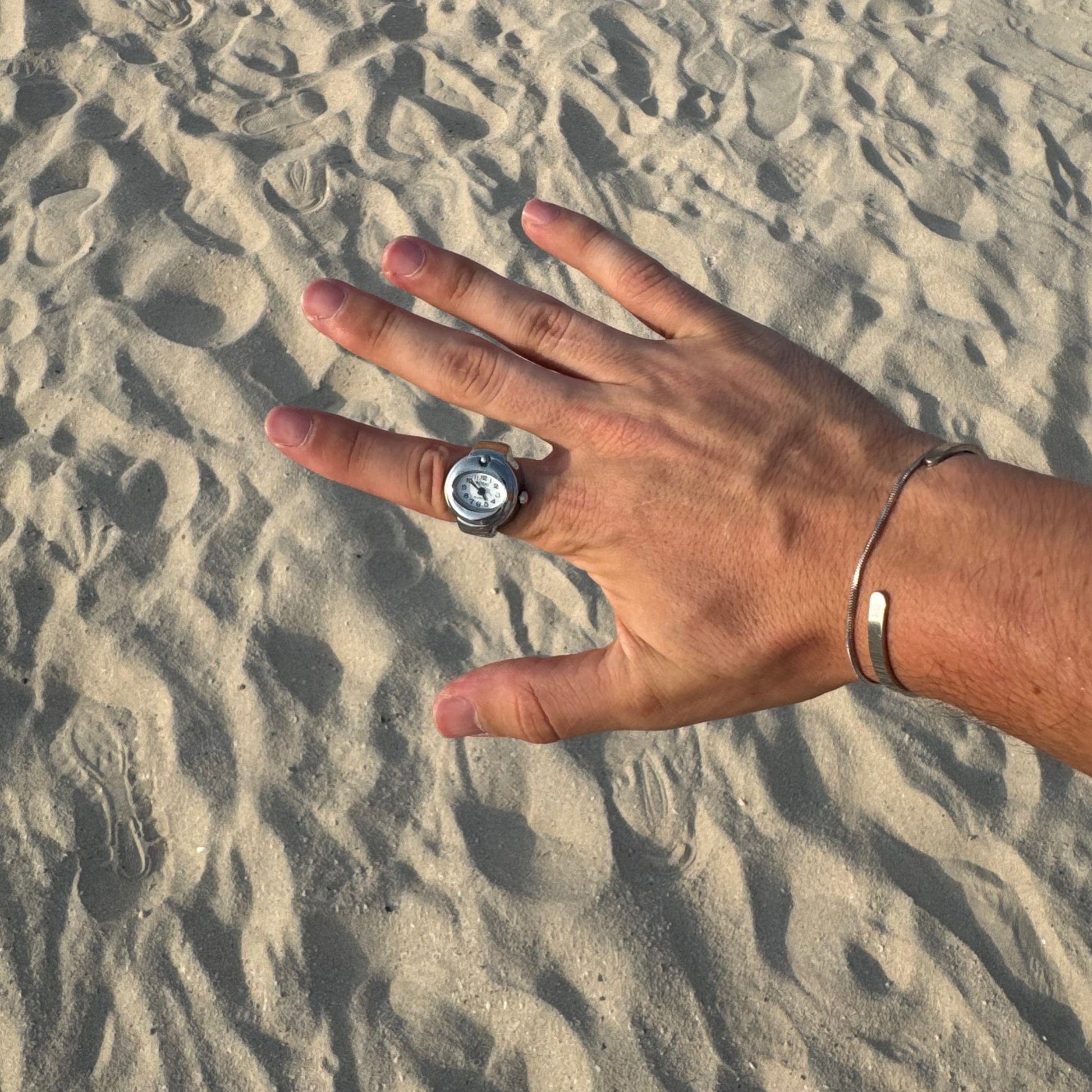 Bague Montre Argent - Cadran Ovale Blanc portée sur un index masculin