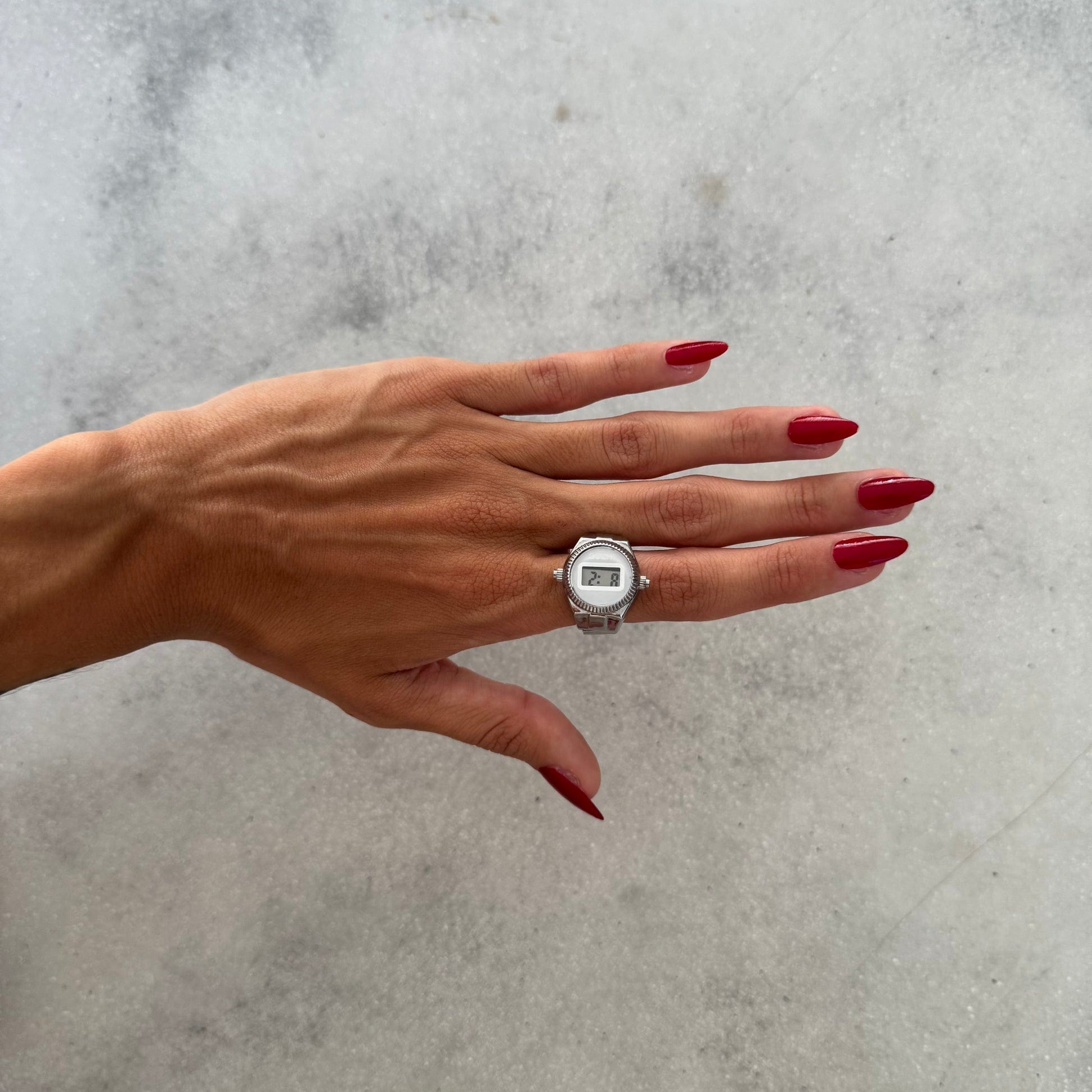 Bague Montre Argent - Cadran Digital Blanc portée sur un index féminin