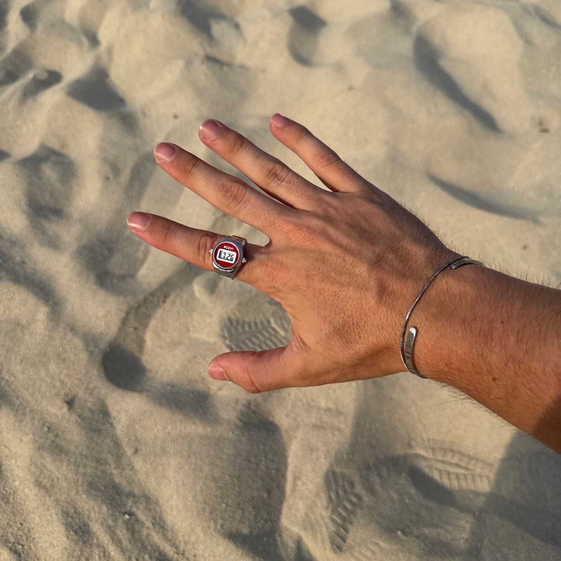 Bague Montre Argent - Cadran Digital Rouge portée sur un index masculin
