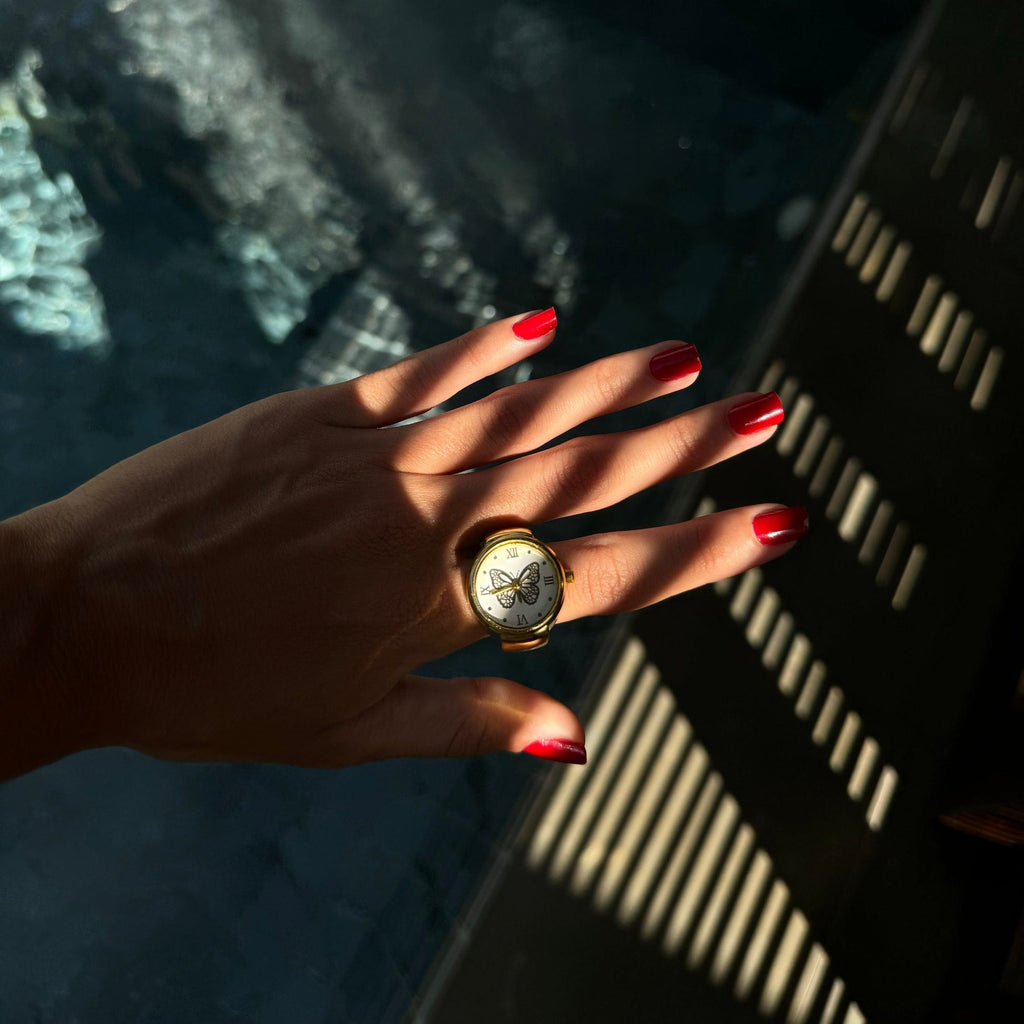 Porter une bague montre dorée cadran papillon